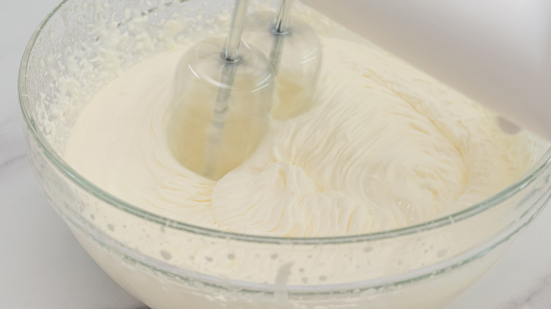 Electric beaters in Cool Whip in a glass bowl