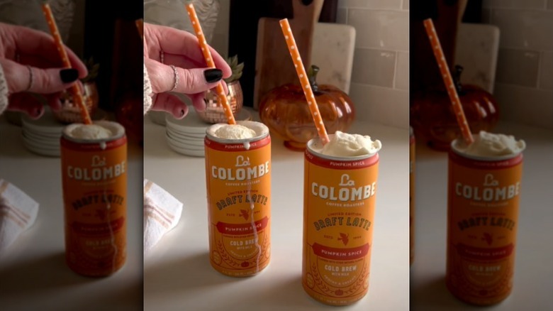 Two cans of La Colombe Pumpkin Spice Draft Latte with ice cream and orange straws.