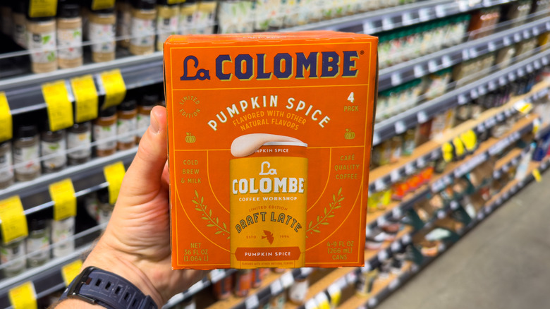 Person holding a pack of La Colombe Pumpkin Spice Draft Latte inside a store