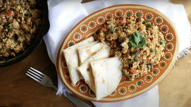 Machaca con Huevos on printed plate with fork and kitchen towel