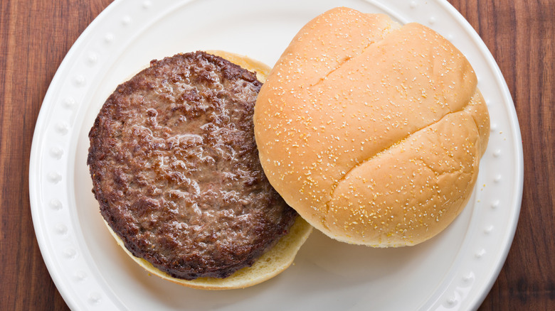 plain burger and bun without toppings on a white plate