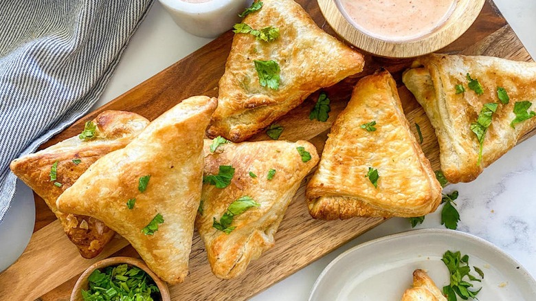 Overview of batch of air fryer samosas with sauce 