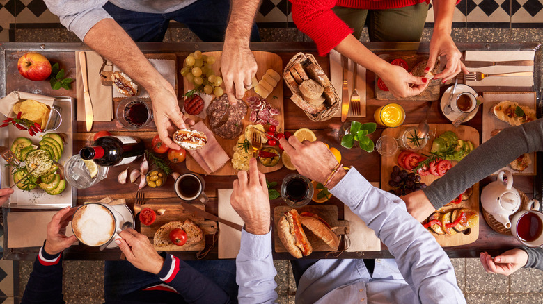 Top-view of friends enjoying a pizza-inspired charcuterie board
