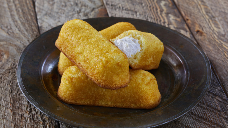 Twinkies stacked beside glass of milk