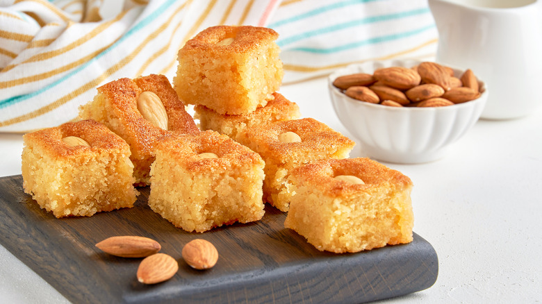 Basbousa with almonds on a wooden board
