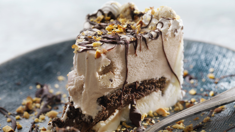 Ice cream cake slice on a blue plate with a fork