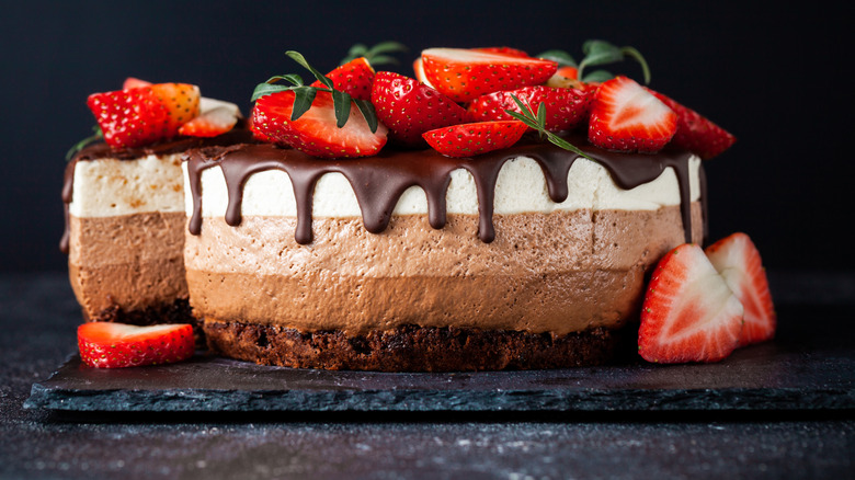 Chocolate cake with strawberry slices against a black background