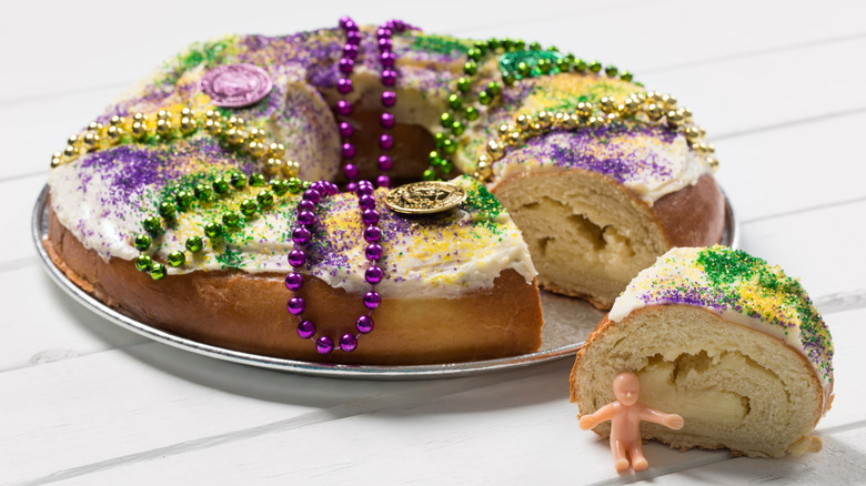 King cake with a baby trinket and Mardi Gras beads