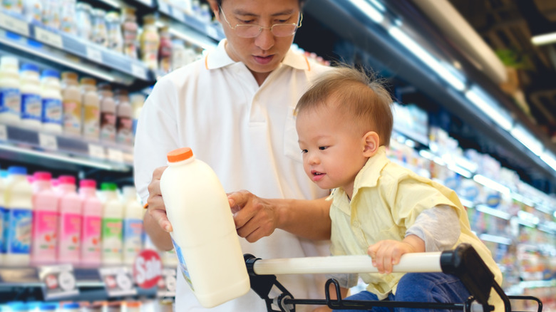 father and child buying milk