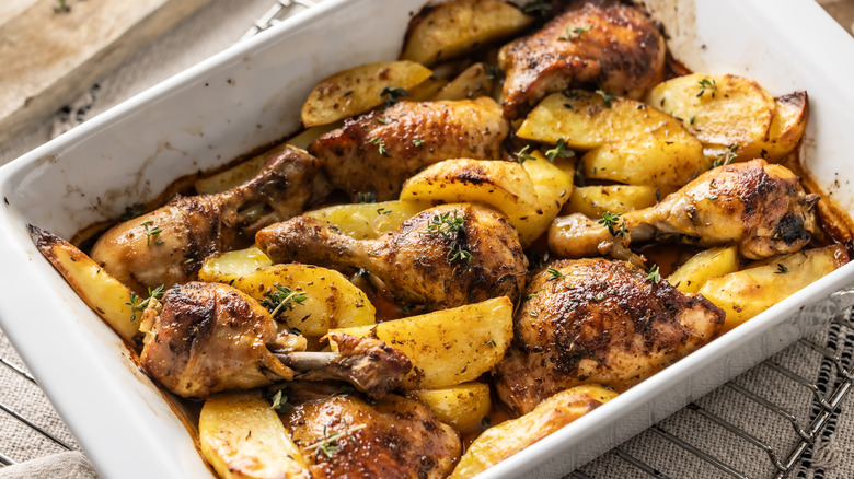 Broiled chicken and potatoes in a serving dish