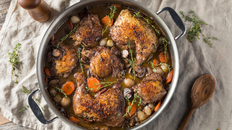 Coq au vin simmering in a metal pot