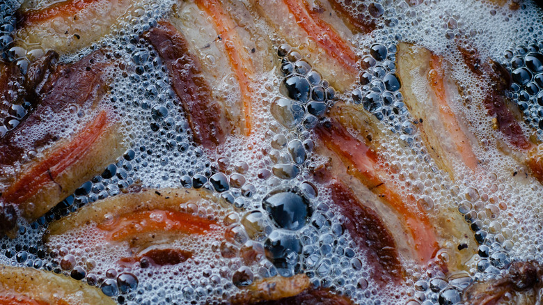 Close-up of bacon frying in bubbling grease