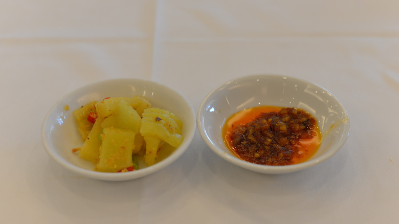 Bowl of pickled cabbage next to bowl of XO sauce
