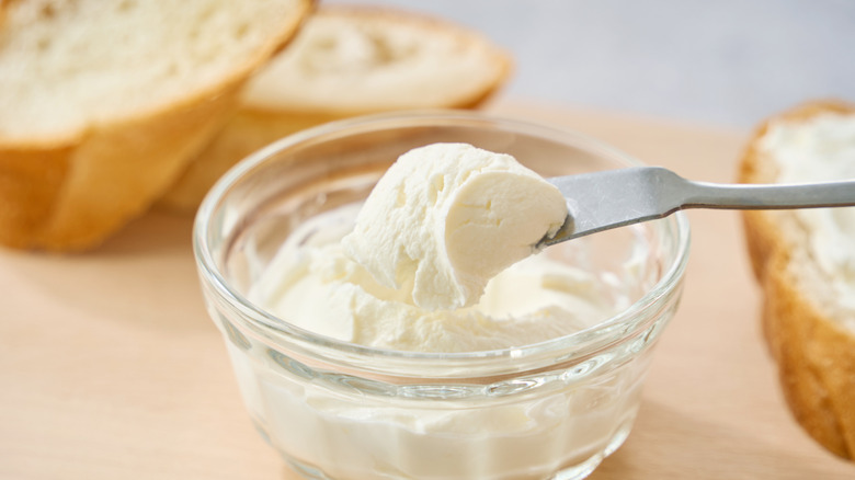 Cream cheese scoop lifting out of bowl