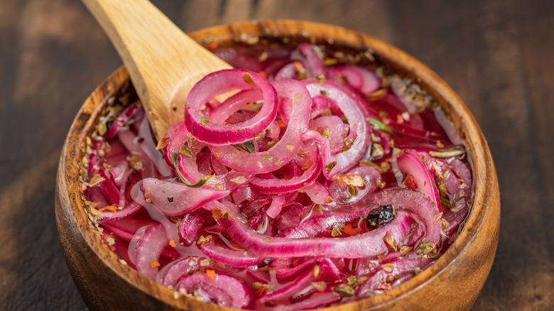 Pickled red onions in wooden bowl