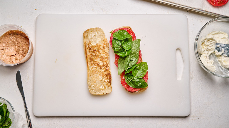 tomatoes and basil added to sandwich