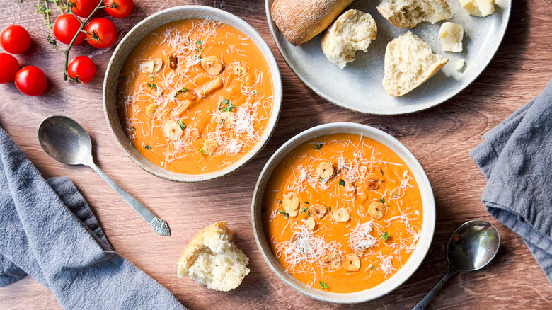 Ultra-creamy white bean tomato soup in serving bowls with garnishes and bread