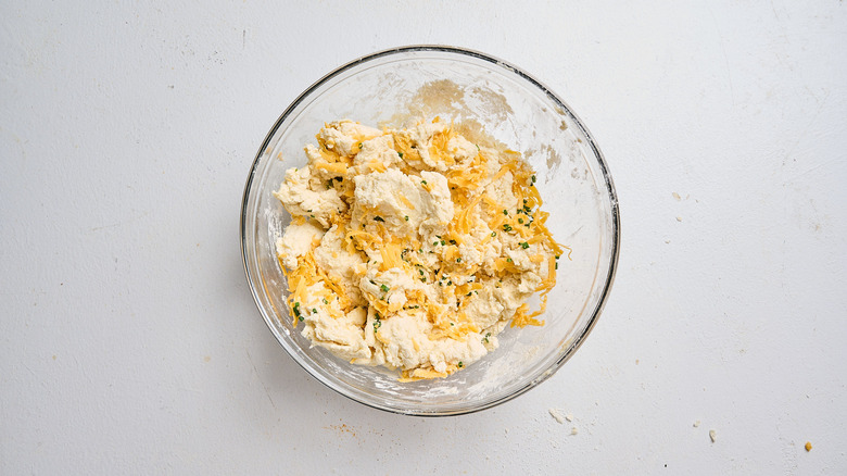 Add the cheddar and chives and gently combine them into the biscuit dough.
