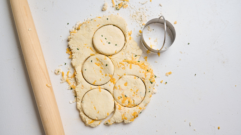 cutting biscuits out of dough on a table