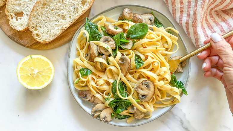 Plate of fettuccini pasta with mushrooms and spinach