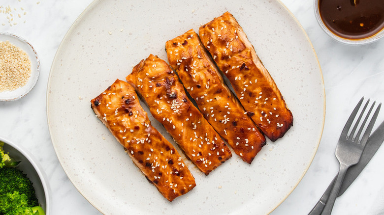 Four baked miso and sesame salmon fillets on plate