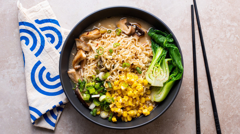 Bowl of vegan miso ramen with bok choy, corn, mushrooms, and green onion