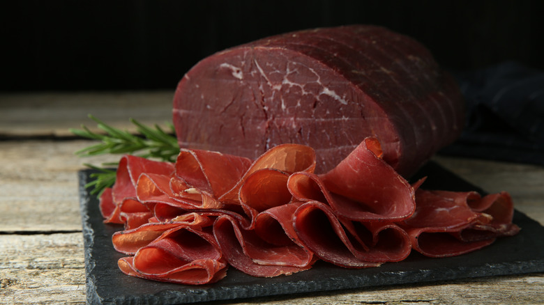 Sliced bresaola and rosemary