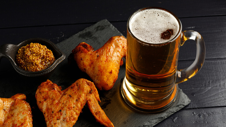 Chicken wings on board with mug of beer