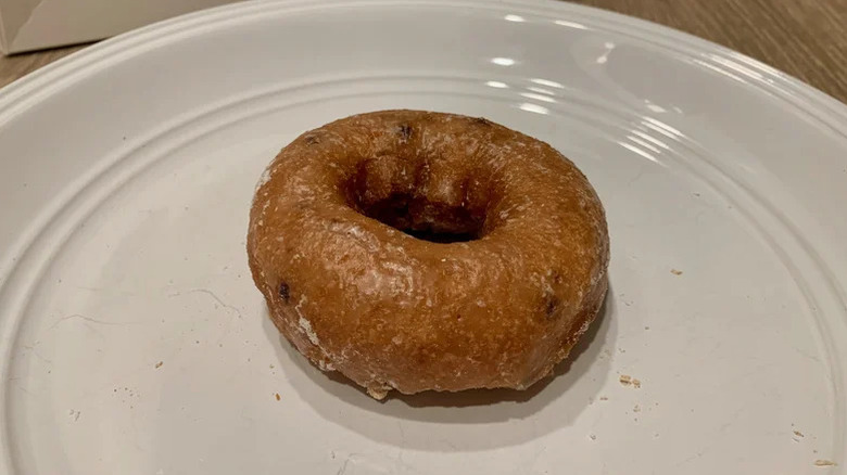 Glazed blueberry donut on white plate