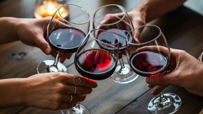 Glasses filled with red wine clinking