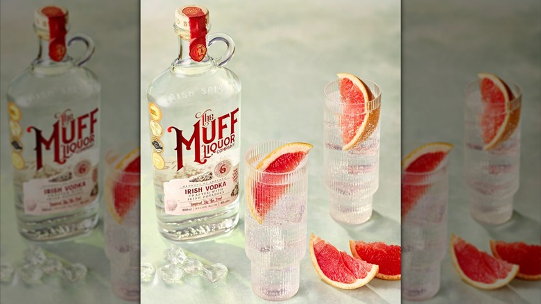 Bottle of Muff Irish Vodka bottle next to glasses with grapefruit garnishes