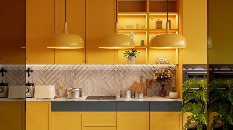 Kitchen with mustard yellow upper and lower cabinets, and three lights
