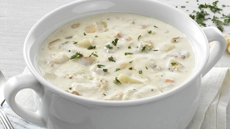 Bowl of clam chowder on a white table