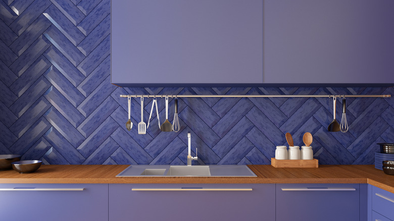 Kitchen with purple cabinets and backsplash, with a warm wooden countertop