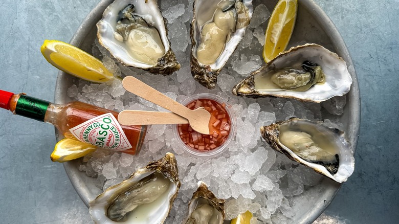 Oysters on ice with bottle of tabasco sauce beside