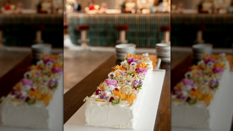 Long rectangular wedding cake decorated with flowers