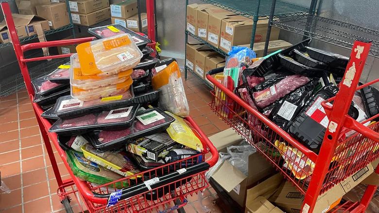 Two red Target shopping carts filled with wasted food products