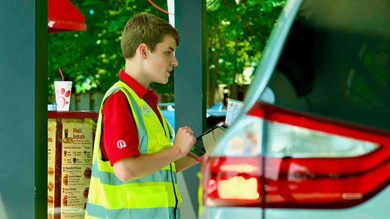 Chick-fil-A employee speaking to customers in a car
