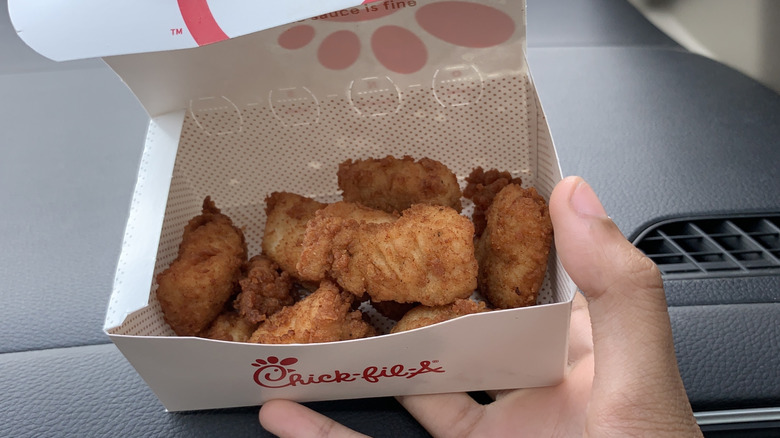 Hand holding carton of Chick-fil-A nuggets
