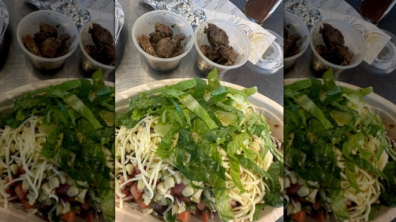 Chipotle bowl with cheese and veggies and extra steak on the side