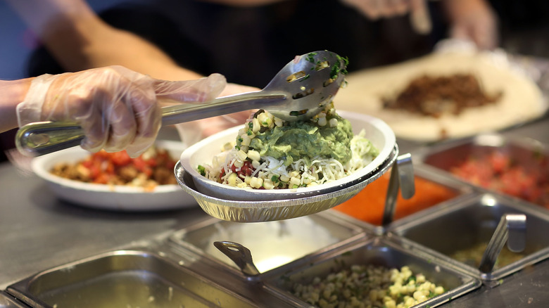 Chipotle worker spooning food into container