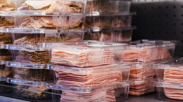 Stacked plastic containers of deli meat