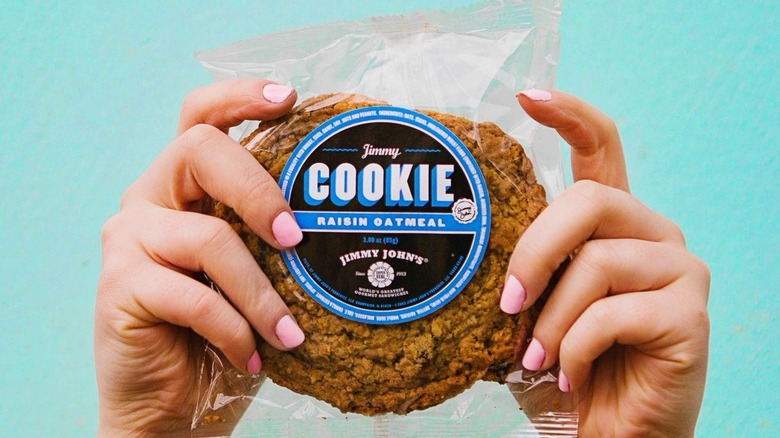 Hands holding up a raisin oatmeal cookie from Jimmy John's