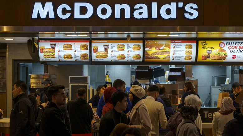 A view of a busy McDonald's, with many people crowded around the counter