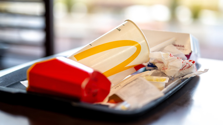 A close-up shot of a McDonald's tray with an empty cup and wrappers