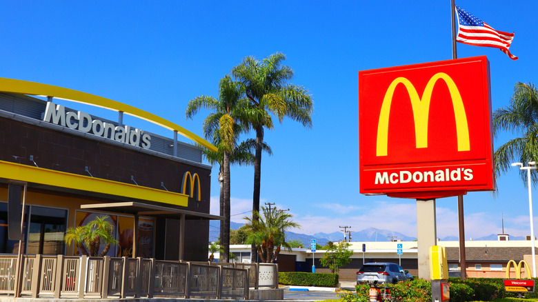 An outside shot of a McDonald's location, with a large sign and an American flag in the background