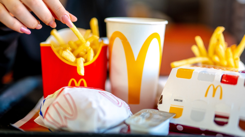A close-up shot of a collection of McDonald's food items, including fries and a drink