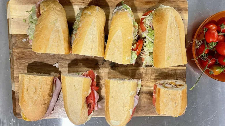 Pub subs cut in half on a wooden cutting board