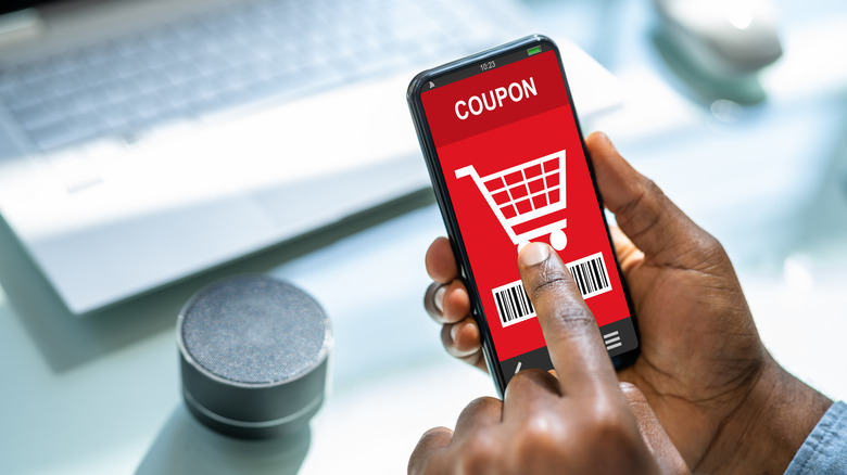 A grocery coupon on a smartphone in someone's hand