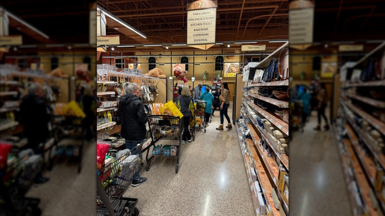 A long line of shoppers with carts stretching down the aisle at Wegmans